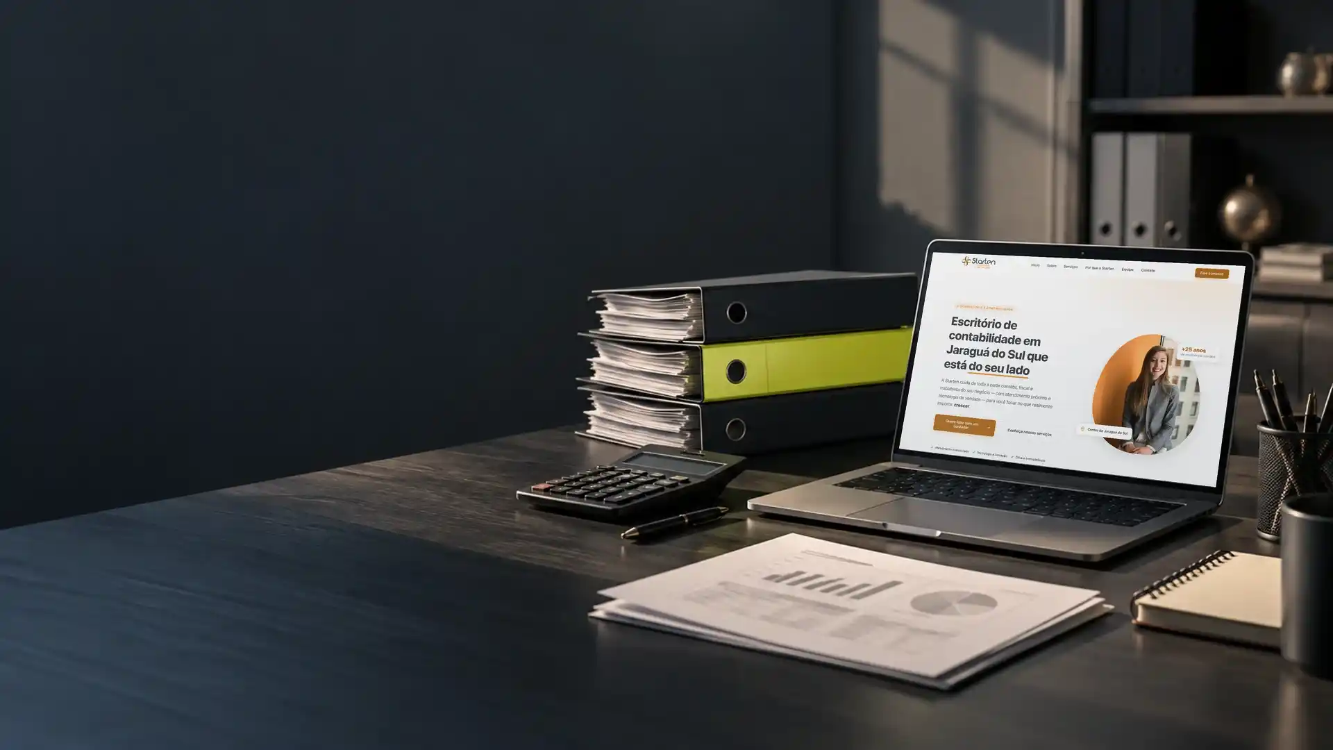 Mesa de um escritório de contabilidade com pastas de arquivo, calculadora, relatórios e notebook