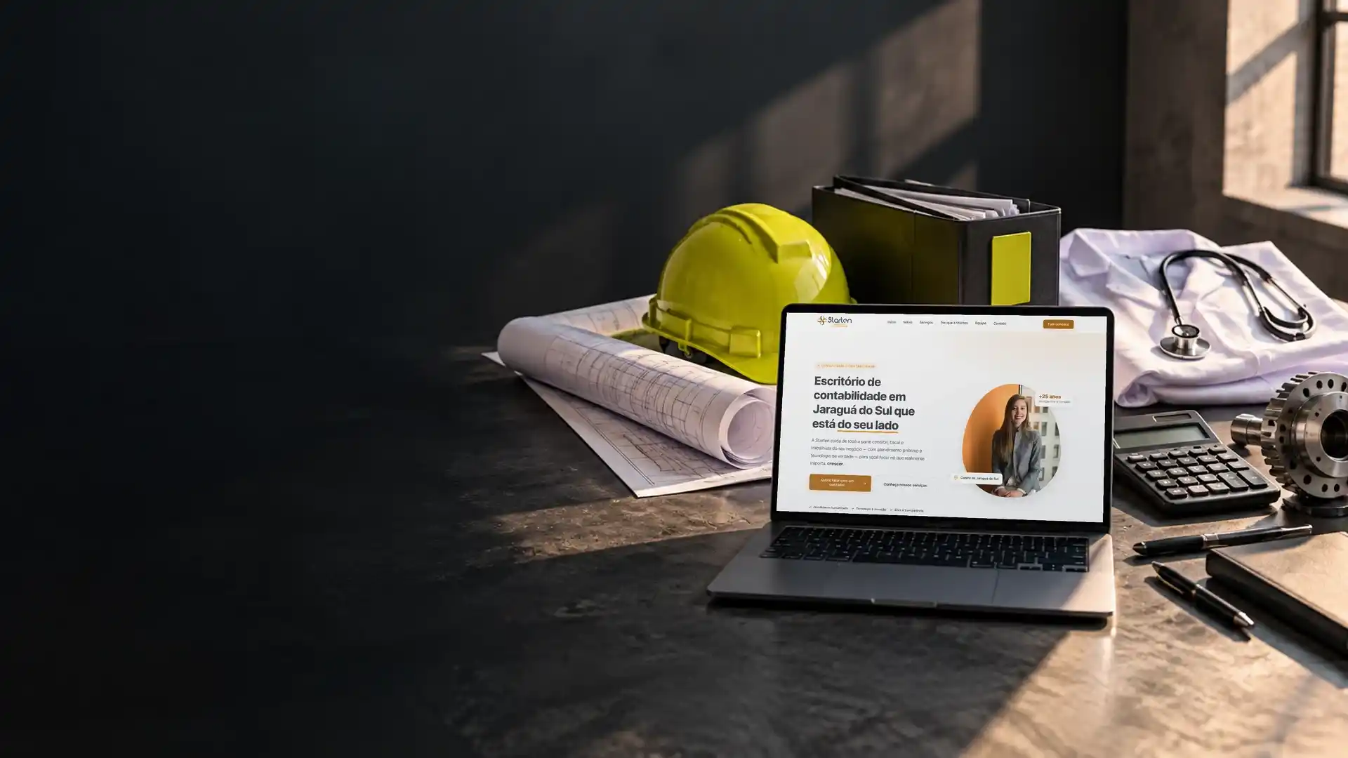 Notebook com o site de um escritório de contabilidade cercado por capacete de obra, estetoscópio, planta e peça industrial